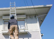 はしごを使って屋根を調査