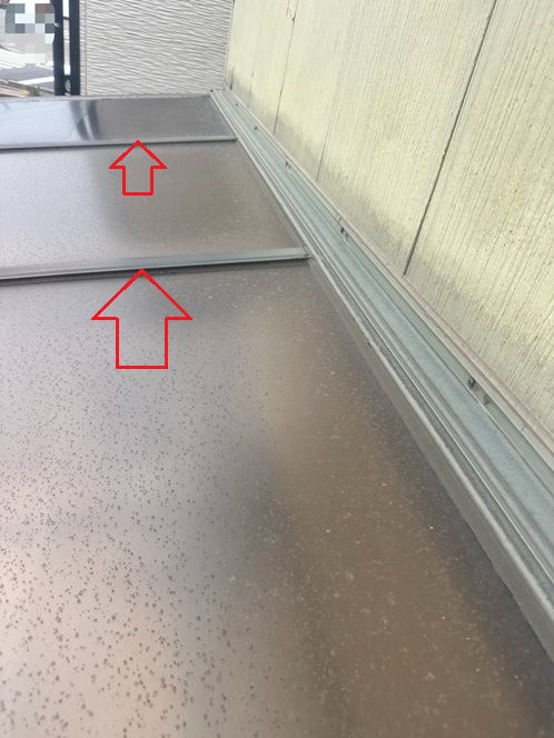 まずはサンルーム屋根のパネルを固定している押さえ材（赤い矢印）を外します。